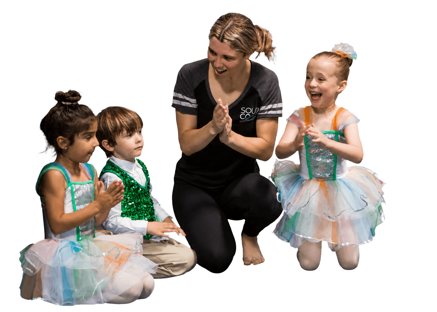A teacher celebrating with three young South Coast Conservatory dancers